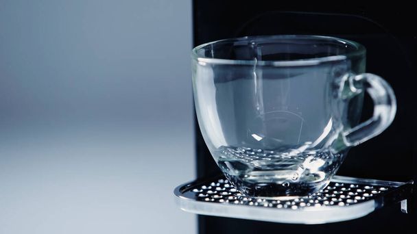close-up van automatische koffiezetapparaat met glazen beker op grijs  - Foto, afbeelding
