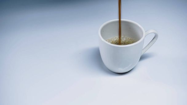 hot espresso pouring into cup on white  - Foto, Imagem