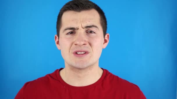 férfi mutatja fogait a kék háttér - Felvétel, videó