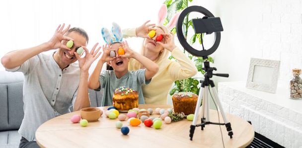 Father, mother and her child enjoy painting Easter eggs. Shop Online for happy easter decoration. Easter eggs - color egg assortment - 写真・画像