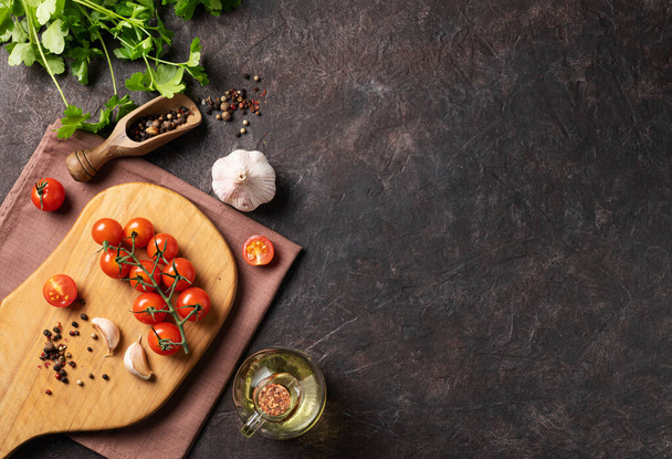 スパイスと新鮮なハーブパセリ,ニンニク,コショウ,暗褐色の背景にトマトと油.おいしいと健康食品の概念。トップ表示とコピースペース. - 写真・画像