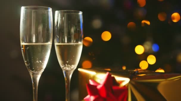 Дві склянки шампанського з подарунком. Новорічна або різдвяна концепція
. - Кадри, відео