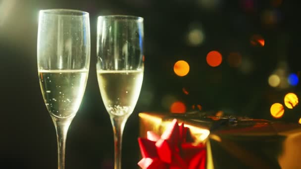 Dvě sklenky šampaňského s dárkem. Nový rok nebo vánoční koncept. - Záběry, video