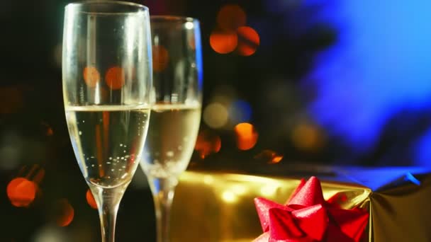 Twee glazen champagne met cadeau. Nieuwjaars- of kerstconcept. - Video