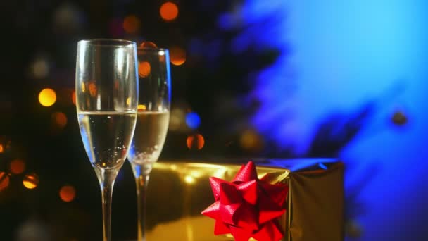 Twee glazen champagne met cadeau. Nieuwjaars- of kerstconcept. - Video