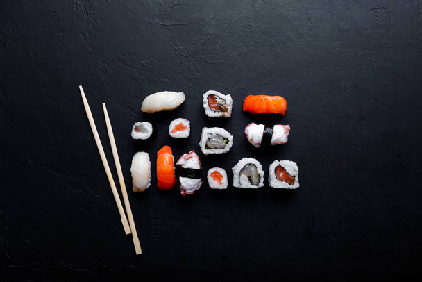 Japanisches Sushi-Essen. Maki-Brötchen mit Thunfisch, Lachs, Garnelen, Krabben und Avocado. Ansicht von Sushi von oben. - Foto, Bild