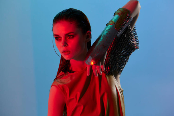 νεαρή γυναίκα Glamor θέτουν κόκκινο φως μεταλλική πανοπλία στο χέρι αναλλοίωτη - Φωτογραφία, εικόνα