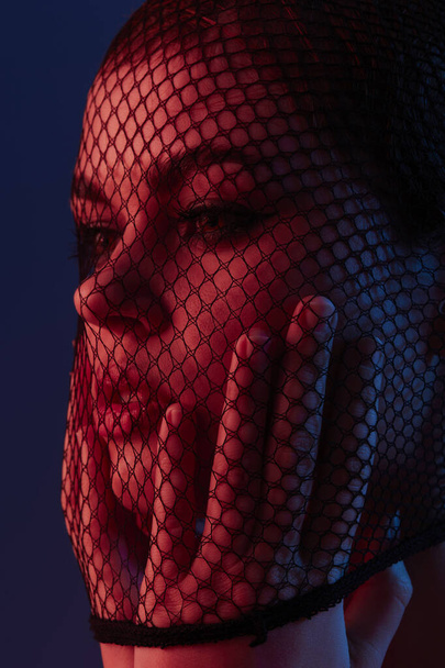 beautiful woman posing mesh on the face neon isolated background - Foto, Imagem