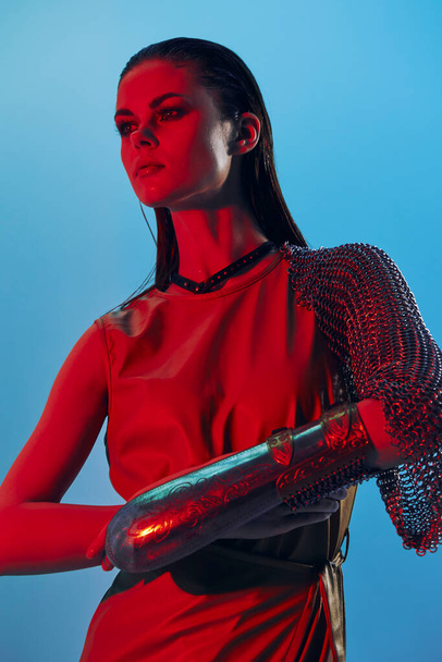 young woman Glamor posing red light metal armor on hand isolated background - Valokuva, kuva