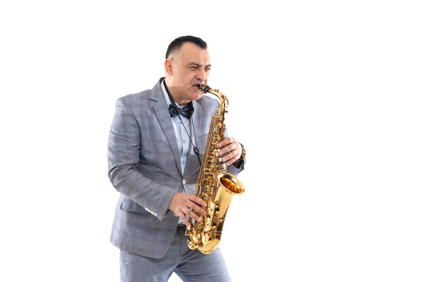 Emotional Musician man in a suit plays on saxophone isolated on white background - Valokuva, kuva