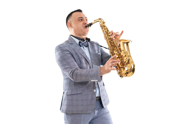 Musician man in a suit plays on saxophone isolated on white background - Φωτογραφία, εικόνα