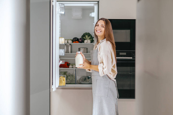 Young woman taking food from the fridge - Foto, Imagem