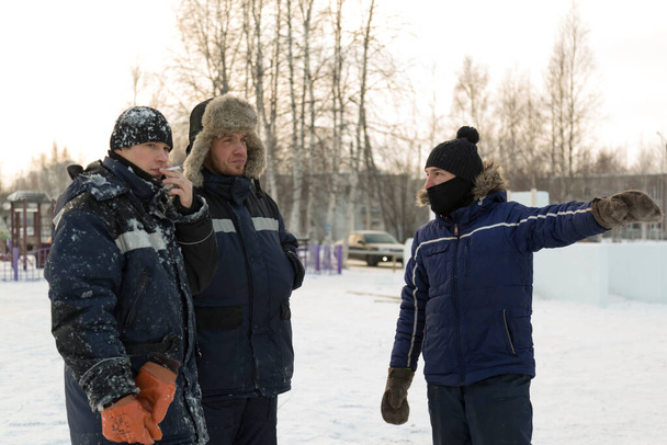Tres trabajadores en el lugar de reunión de la ciudad de hielo
 - Foto, imagen