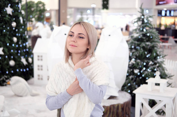 Portrait of a girl with blond hair on the background of a Christmas tree. Selective focus - Φωτογραφία, εικόνα