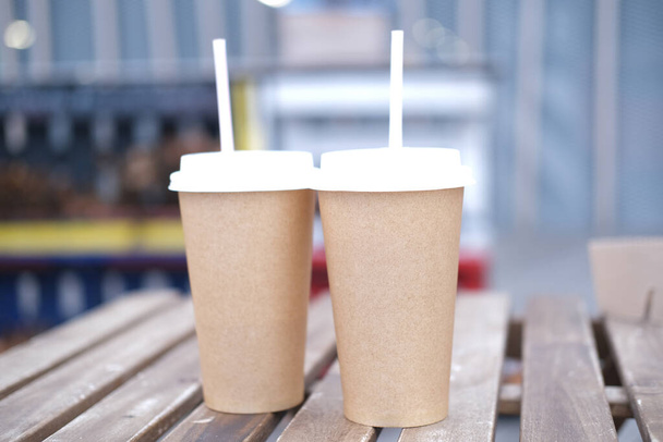 Paper cups stand on a wooden table. Takeaway coffee.  - Foto, immagini