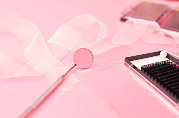 Ausrüstung für Wimpernverlängerungen auf rosa Hintergrund. Hochwertiges Foto - Foto, Bild
