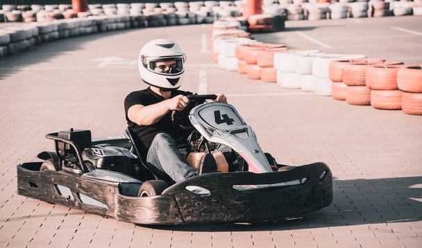 A young man drives a go kart at circuit - 写真・画像
