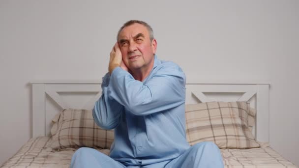 Un uomo anziano a letto soffre di forti dolori. Concetto di malattia domestica - Filmati, video