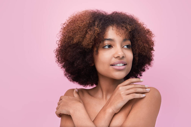 Nuori nainen ruskeaverikkö hiukset aiheuttaa vastaan vaaleanpunainen seinä - Valokuva, kuva