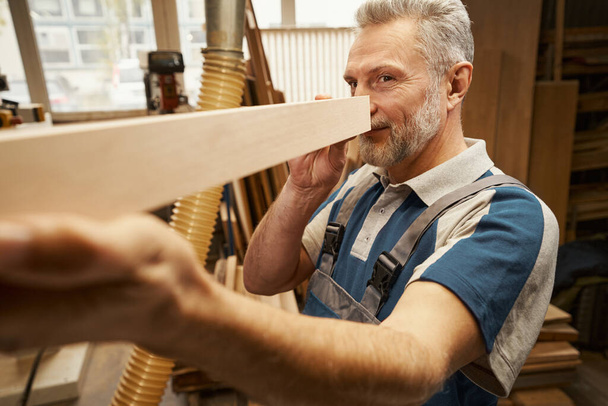 Positive delighted craftsman working at furniture manufacture - Photo, Image