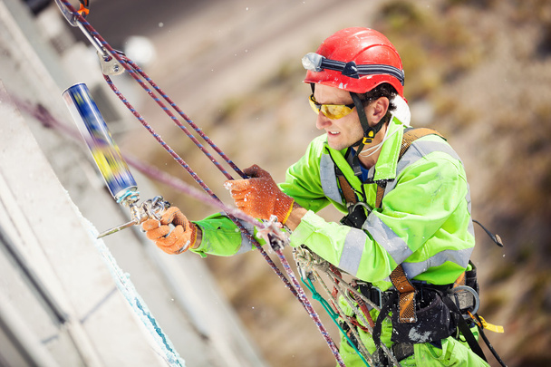 Промисловий альпініст на будівлі під час зимових робіт
 - Фото, зображення
