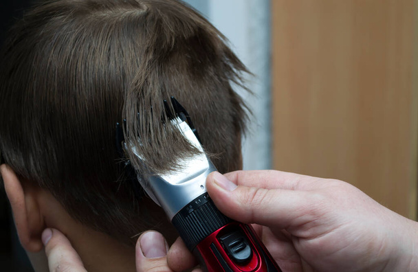 Sous la coupe de cheveux d'un homme à la maison en raison de la quarantaine, le concept d'hygiène domestique. - Photo, image