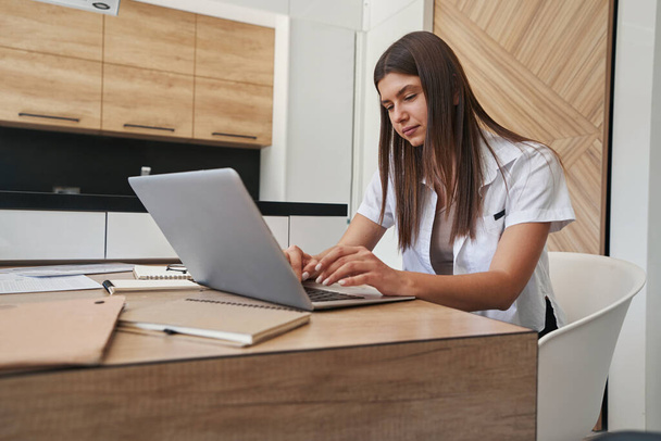 Female telecommuter typing on her notebook computer - Foto, Bild