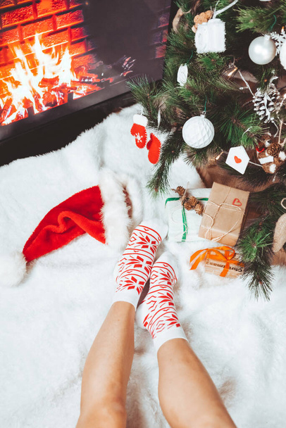 クリスマスツリーグリーティングカード近くの靴下に女性の足 - 写真・画像