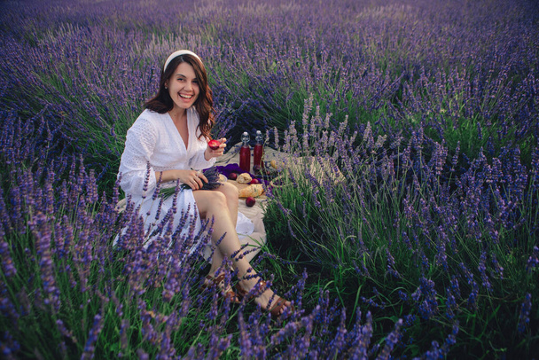 gorgeous woman in white dress at lavender field having picnic - Photo, Image