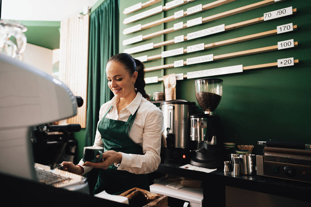Caucasian female barista at work making coffee - Фото, зображення