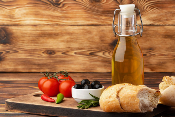 Italian ciabatta bread with olive oil on wooden background - Foto, Imagem