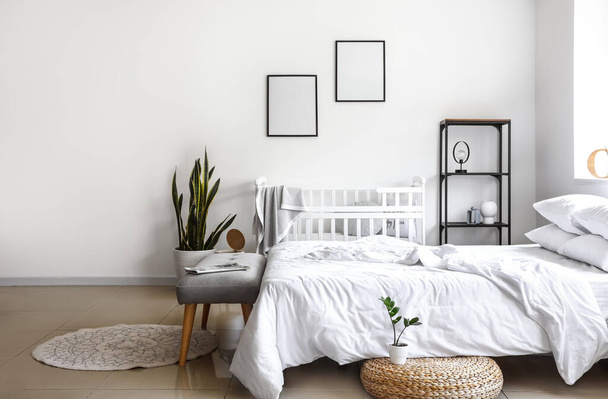 Interior of white bedroom with crib and frames - Photo, Image