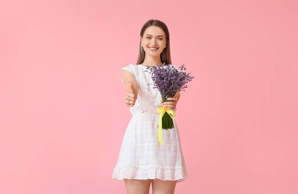 Beautiful young woman with bouquet of lavender showing thumb-up on color background - Zdjęcie, obraz