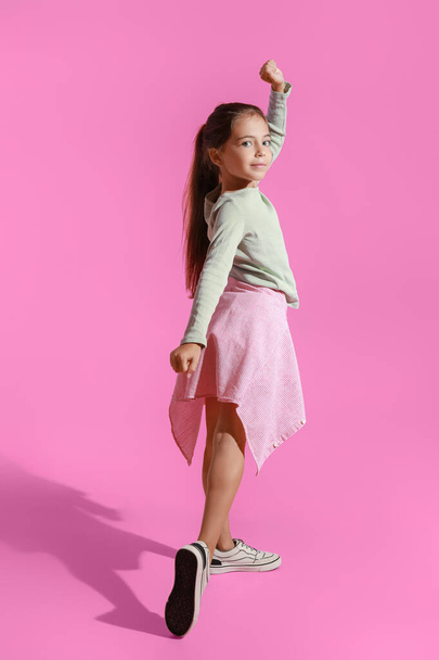 Adorable little girl dancing on pink background - Fotografie, Obrázek