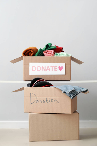Açık arkaplanda bağış giysileri olan karton kutular. - Fotoğraf, Görsel