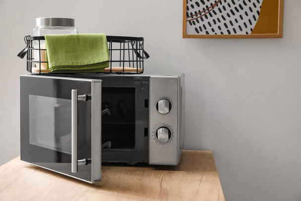 Microwave oven on wooden tabletop in modern kitchen - Photo, image