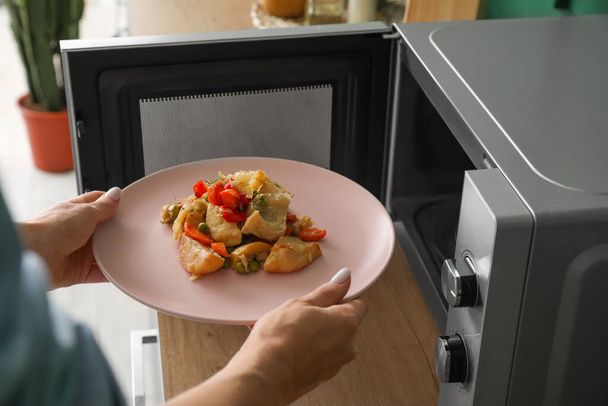 Mujer calentando comida en horno microondas - Foto, Imagen