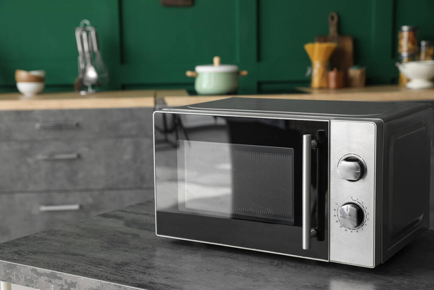 Modern microwave oven on table in kitchen - Photo, Image