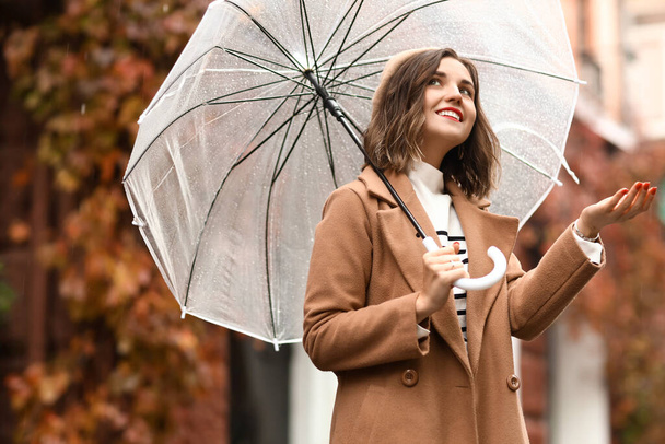 雨の秋の日に傘を持つ幸せな女性 - 写真・画像