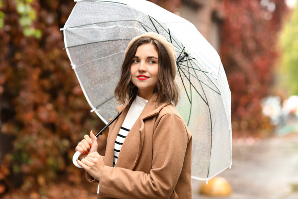 Beautiful fashionable woman with umbrella on autumn day - Photo, Image