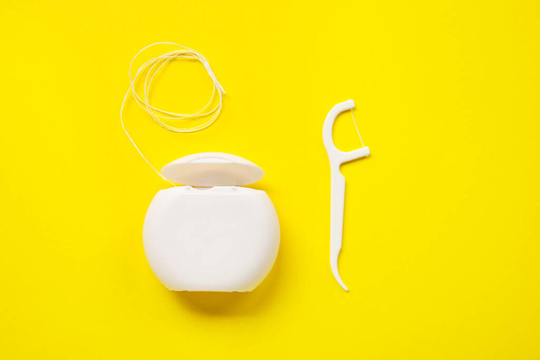 Dental floss and toothpick on yellow background - Photo, Image