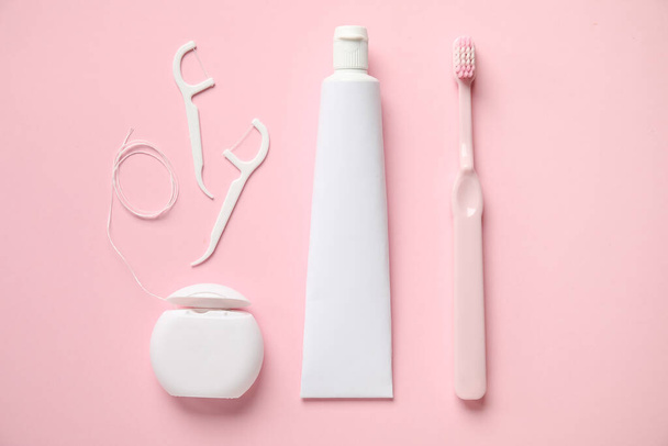 Zahnseide, Zahnstocher, Paste und Bürste auf rosa Hintergrund - Foto, Bild