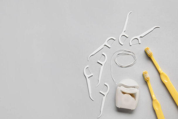 Tandzijde, tandenstokers en borstels op een lichte achtergrond - Foto, afbeelding
