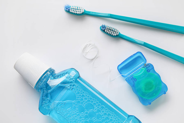 Zahnseide mit Zahnbürste und Spülung auf weißem Hintergrund - Foto, Bild
