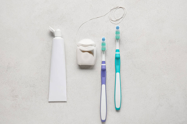 Dental floss with tooth brushes and paste on white background - Foto, Bild