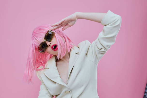 Gyönyörű divatos lány visel napszemüveg rózsaszín haj pózol rózsaszín háttér változatlan - Fotó, kép