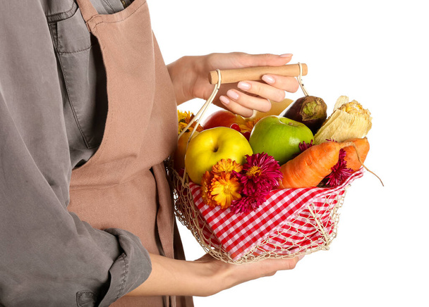 Mujer sosteniendo cesta con diferentes alimentos saludables sobre fondo blanco. Fiesta de la cosecha - Foto, Imagen