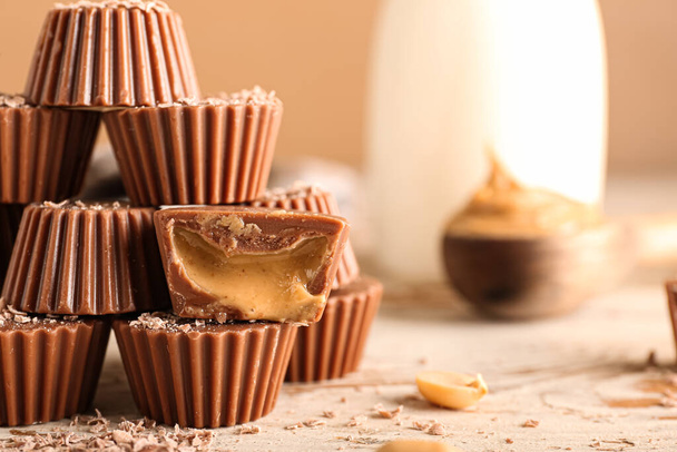 Gustose caramelle al cioccolato con burro di arachidi su sfondo di legno, primo piano - Foto, immagini