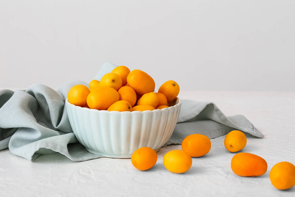 Bowl with tasty kumquat fruits  on light background - Foto, Imagem