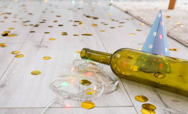 Botella vacía con decoración en el suelo en la habitación después de la fiesta - Foto, imagen